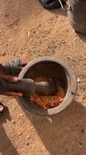 Person grinds ingredients with mortar and pestle in Nigeria