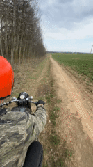 Motorcyclist rides dirt road in rural Belarus