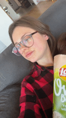 Woman enjoys chips and yogurt snack in Budapest apartment