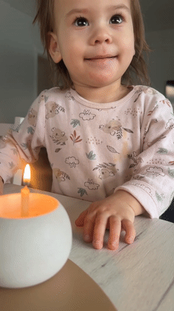 Toddler celebrates with candle and flowers in Russian home