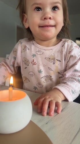 Toddler celebrates with candle and flowers in Russian home