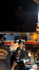 Train crosses through motorcycle traffic in Bắc Nha Trang