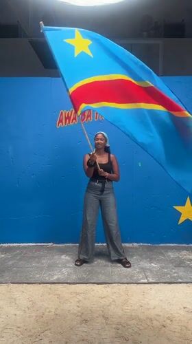 Woman waves Congo flag in Montreuil, France