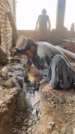 Jackhammer breaking concrete in a Kandahar trench