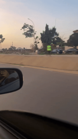 Driver documents golden hour street scenes in Abuja