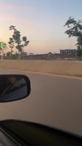 Driver documents golden hour street scenes in Abuja