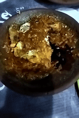 Sambal being ground fresh alongside fried chicken and rice