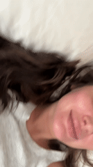 Person with dark hair filmed resting on white bedding in Moscow