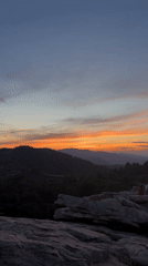 Group watches sunset from rocky outcrop in Spain