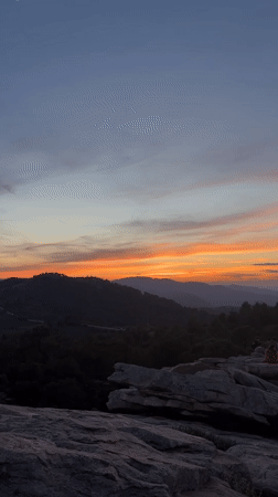 Group watches sunset from rocky outcrop in Spain