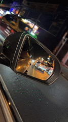 Nighttime traffic observed through car mirror in Thailand