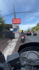 Motorcyclists ride on sidewalk in Kuta Selatan, Indonesia