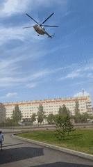 Helicopter observed flying over urban area, child in stroller