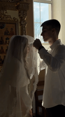 Wedding ceremony observed at church with veil kiss moment