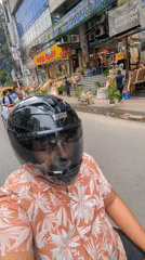 Motorcyclist rides blue Honda through busy Dhaka street