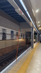 Yellow-green subway train arrives at underground metro station