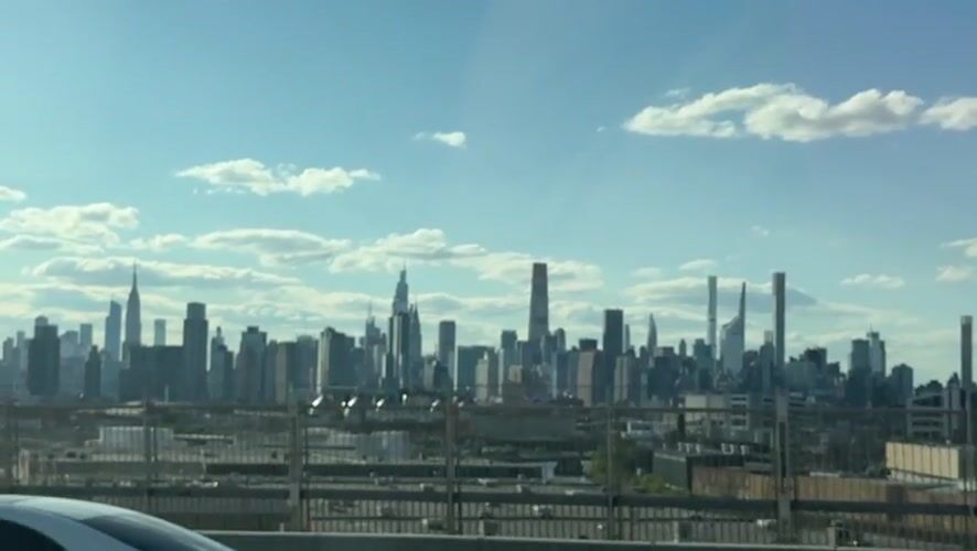 NYC skyline viewed from elevated position amid clear skies