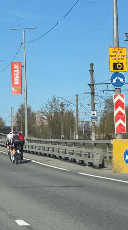 Three cyclists cross bridge in sunny Lisy Nos