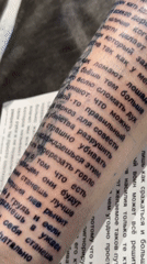 Person displays extensive Russian text tattoo on forearm in Moscow