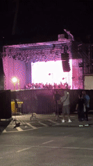 Nighttime outdoor DJ set with LED stage visuals and crowd