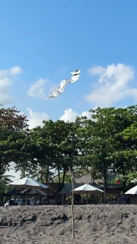 Morning beach visit captures temple, kite, swimmers in Mengwi