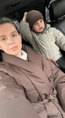 Mother and child shelter in car during rain in Klin
