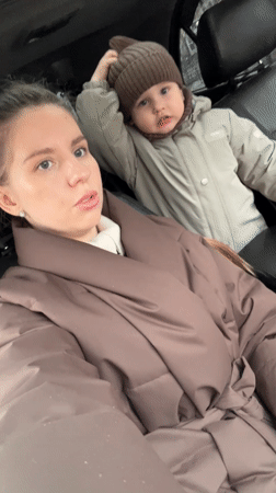 Mother and child shelter in car during rain in Klin