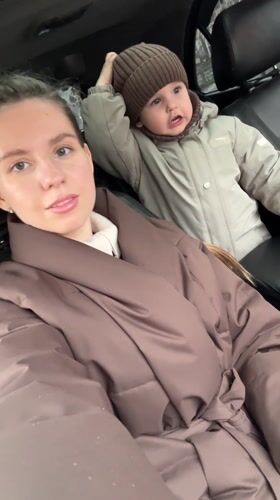 Mother and child shelter in car during rain in Klin