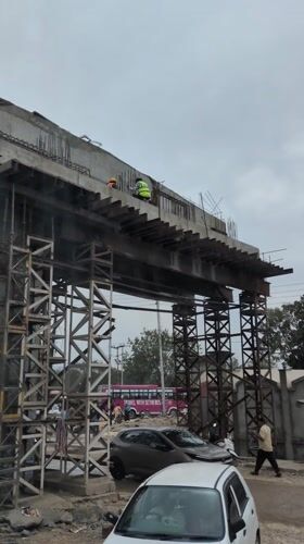 Construction workers building overpass in Jassur, India