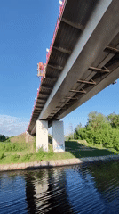 Flag-decorated pedestrian bridge observed over canal in Yakhroma