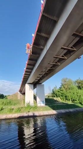 Flag-decorated pedestrian bridge observed over canal in Yakhroma