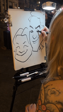 Street artist draws caricature on illuminated easel in Belgrade