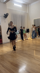 Young dancers practice ballroom routines in mirrored studio