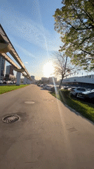 Woman walks near monorail track in Khimki on sunny afternoon