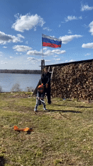 Child plays with stick in sunny yard in Ольховка