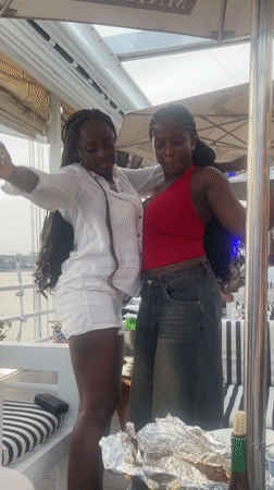 Women celebrate with wine and dancing at Lagos waterfront restaurant