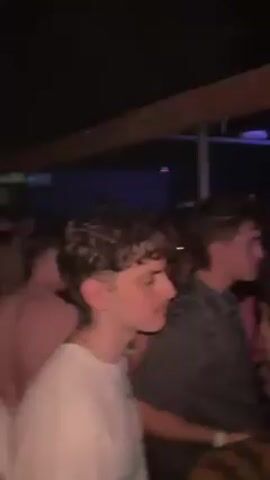 Here is a description of the video:

The video shows a crowded dance floor at a club or party. There are many young people dancing and interacting with each other. The lighting is dim, with colorful stage lights creating a vibrant atmosphere. Some people are wearing casual clothing, while others are dressed up. The overall impression is that of a lively and energetic social gathering.