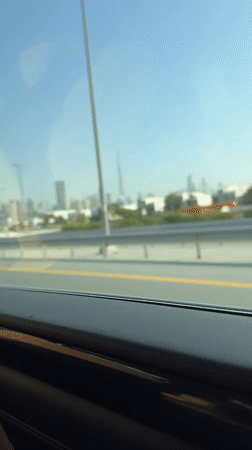Early morning highway drive captures Dubai skyline view
