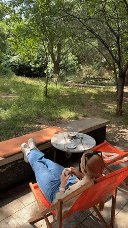 Woman relaxes with pet Chihuahua on Podgorica patio