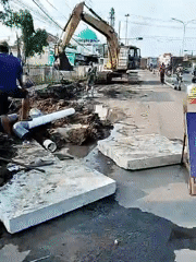 Road construction crew operates excavator in Kebakkramat, Indonesia