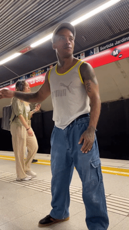 Gesturing on a Barcelona metro platform, July 2026