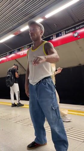 Gesturing on a Barcelona metro platform, July 2026