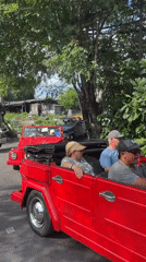 Red Volkswagen convoy drives through Denpasar morning traffic
