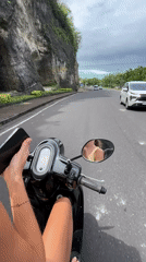 Scooter rider filmed on clifftop road near Uluwatu Temple