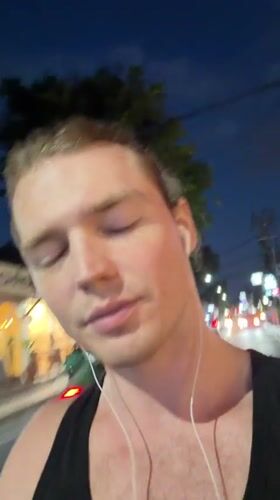 Man films himself making gestures on Kuta street