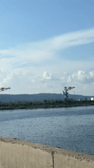 Cycling past a crane-lined waterfront in Chaikovsky, Russia
