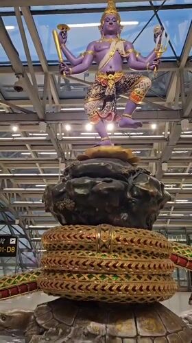 Multi-armed deity statue display captured at Thai airport