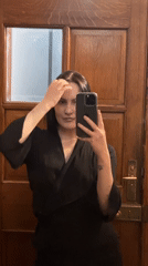 Woman takes selfie at wooden door in London