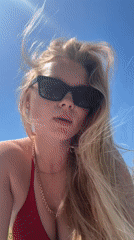 Beachgoers sunbathe on grass in Herzliya during sunny day