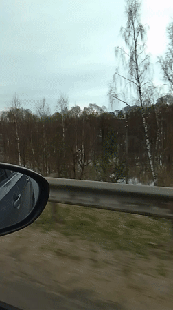 Car window view captured in Kremyonki showing guardrail, water